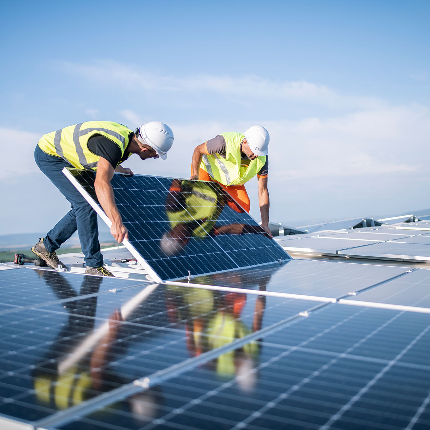 Zwei Solarteure auf Dach installieren ein Solarmodul